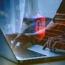 man typing on laptop with an overlay of network of red lines with a red shield with a lock