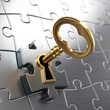 Gold key in silver puzzle piece lock