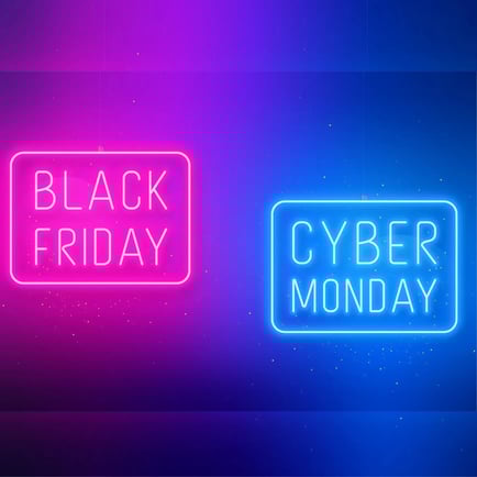 Black Friday neon pink text written in a box next to cyber monday written in neon blue in a box on a dark background